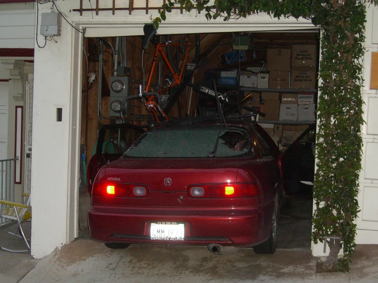 the car is parked in the garage with a bike mounted on top of it