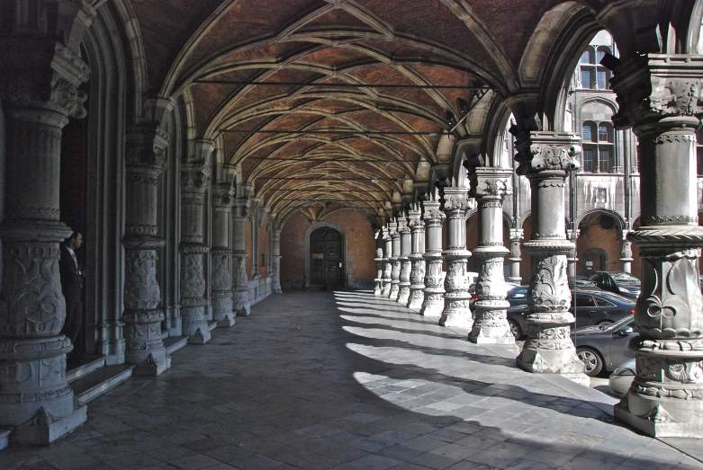 a line of stone columns and arches with long windows