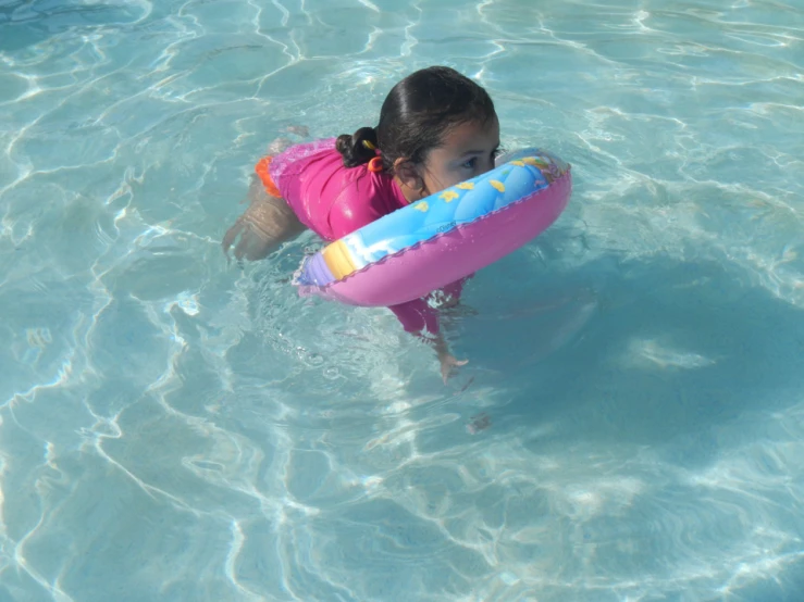 a girl in a swimming suit and with an inflatable disk