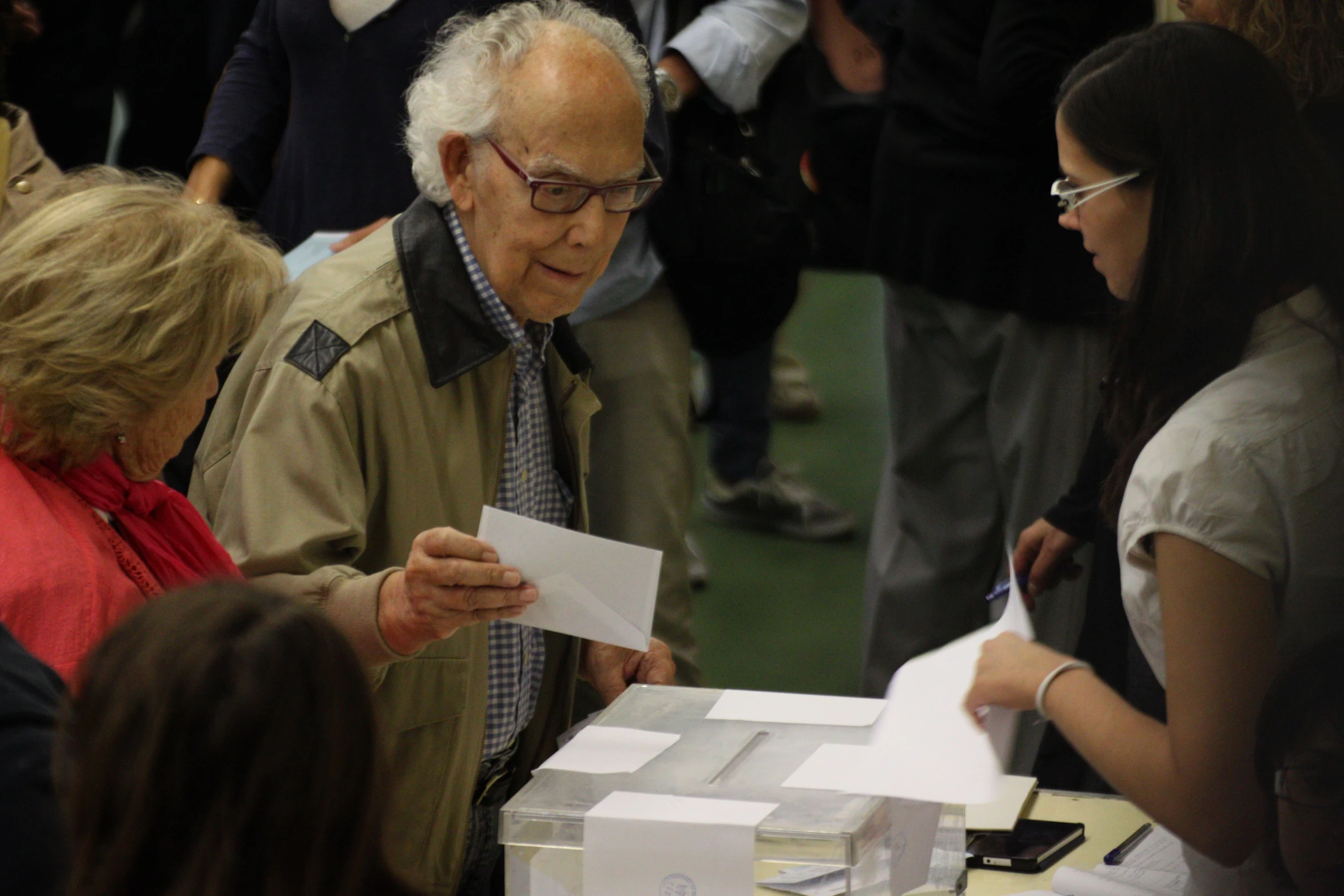 a man in glasses, holding a piece of paper and checking out soing