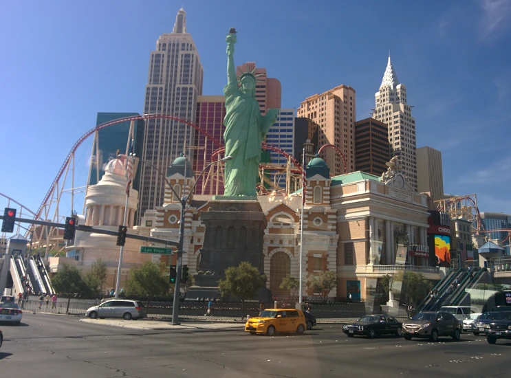 an urban scene with tall buildings and cars and a statue of liberty in the center