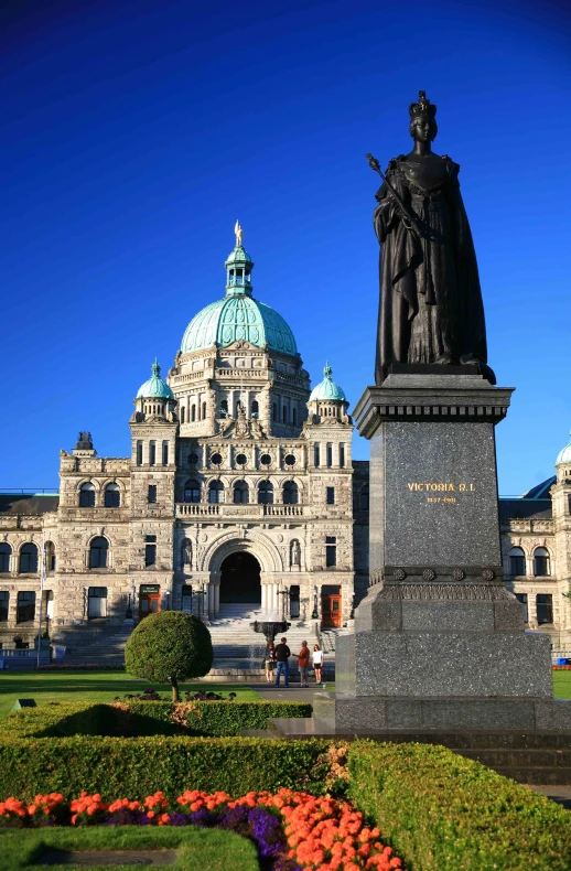 a large statue sits in front of a building with a dome