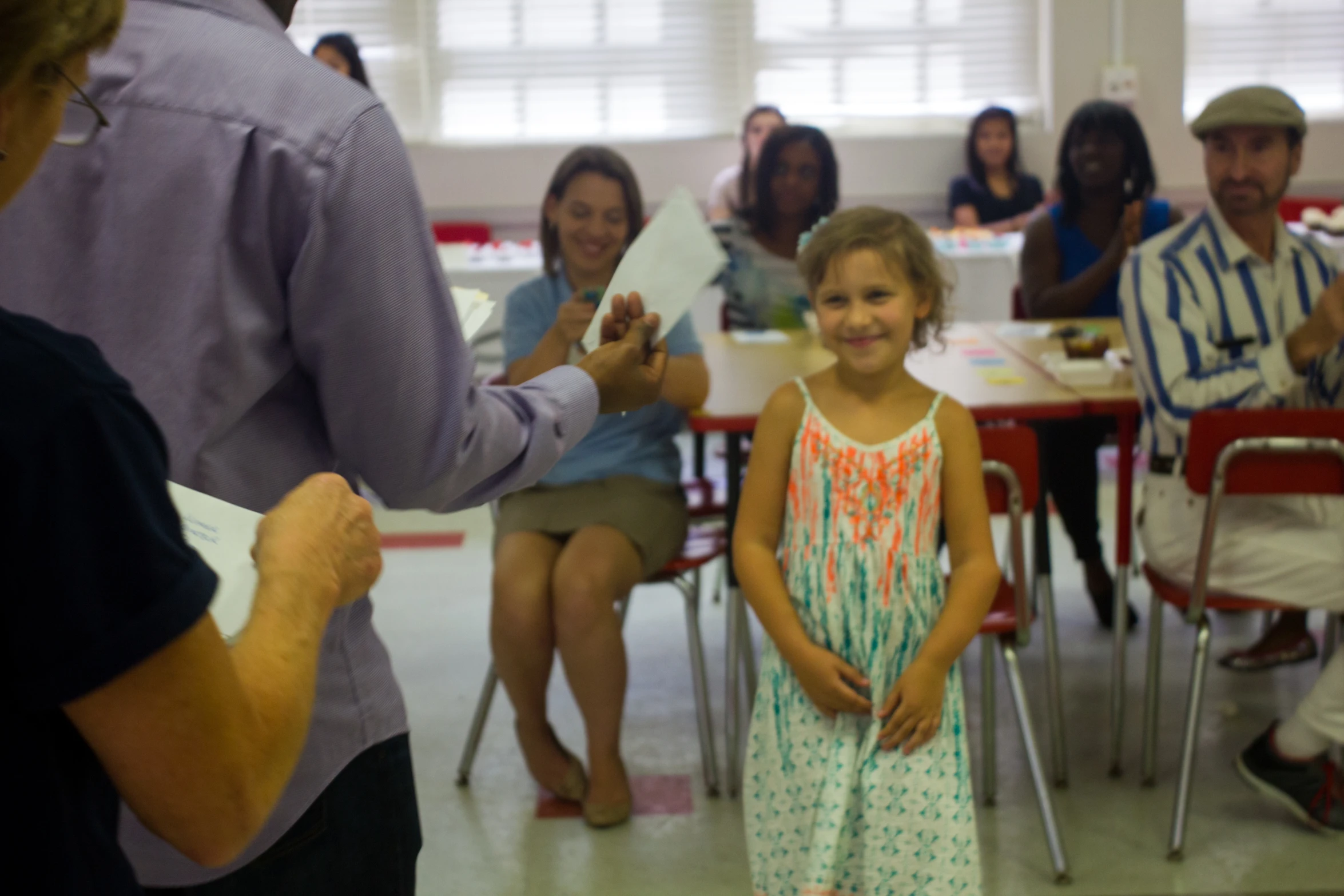 small child standing in front of some people