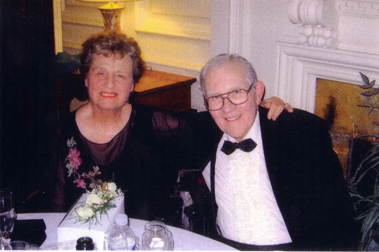 a man and woman in tuxedo sitting at table