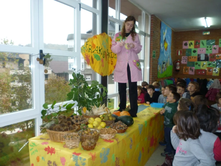 a person with umbrella stands on table covered with vegetables