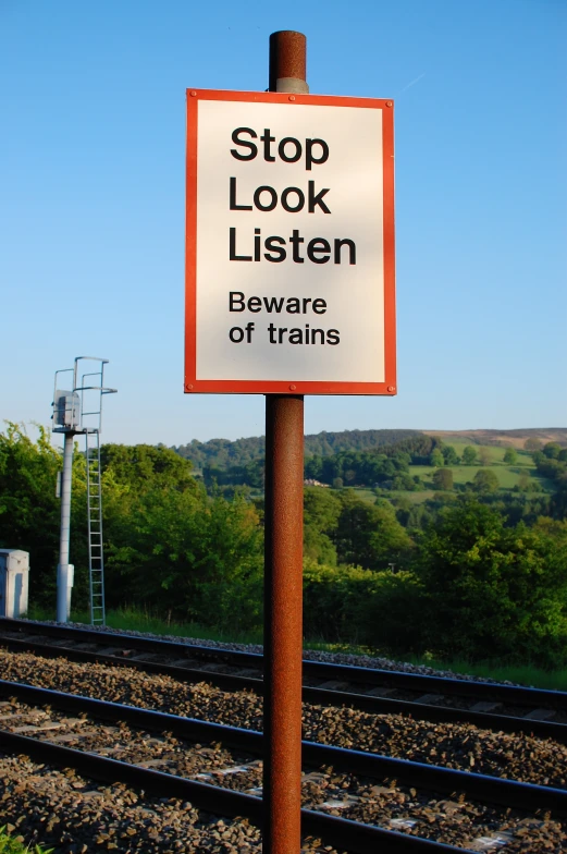 a red and white sign on top of a pole