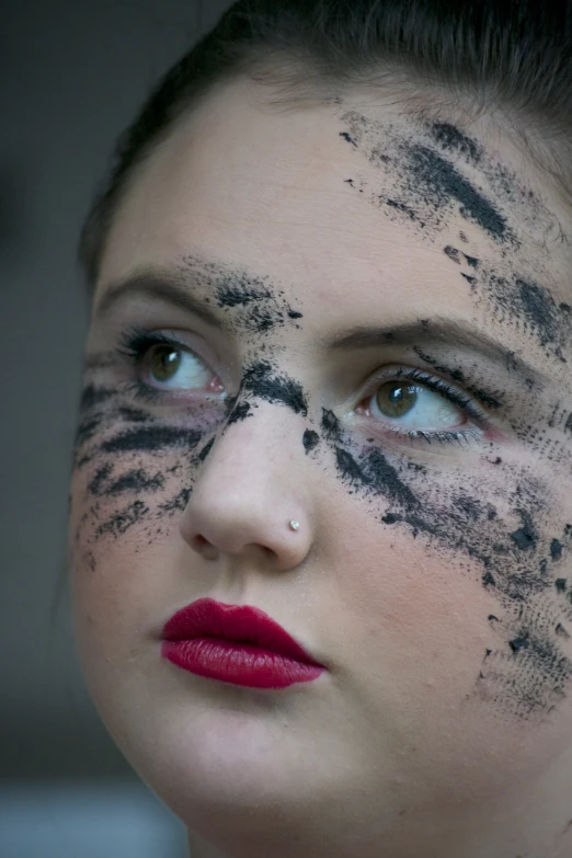 a woman with black and white paint and red lipstick