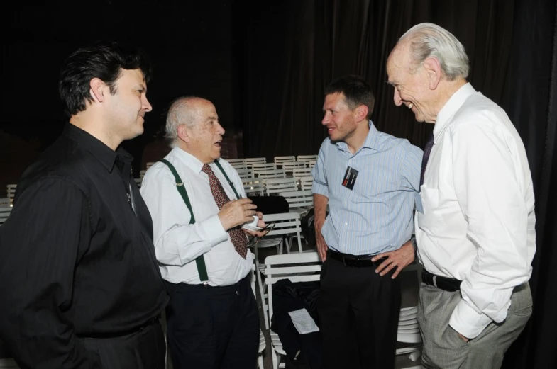 several men in suits talking together next to each other