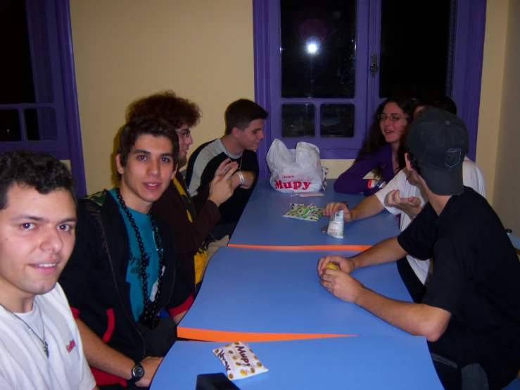 several people are sitting at a table and eating food