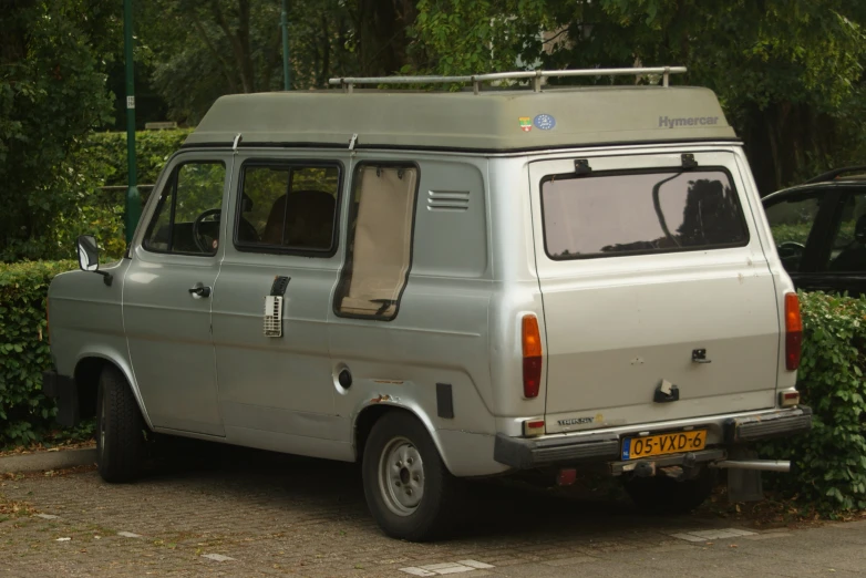 there is a grey mini van parked on the side of the road