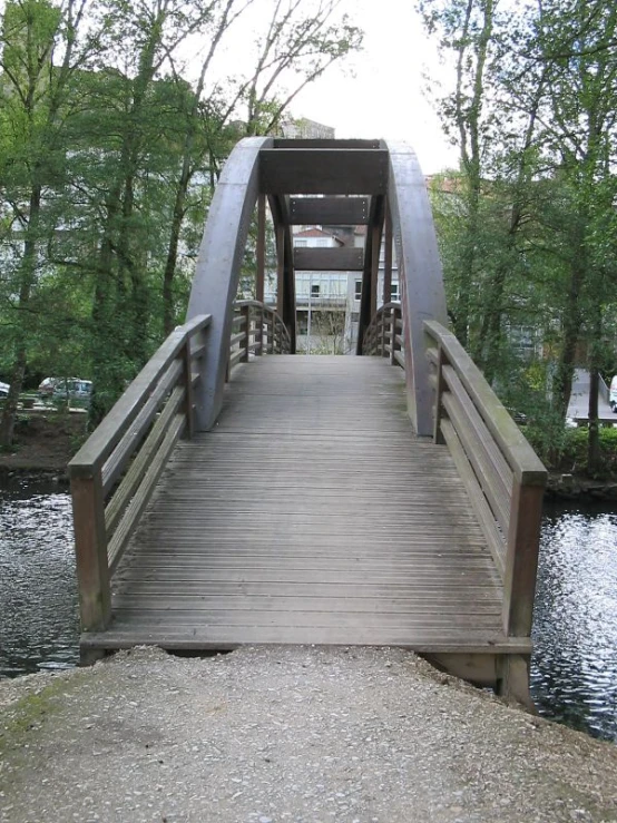 a wooden bridge across the water in a park