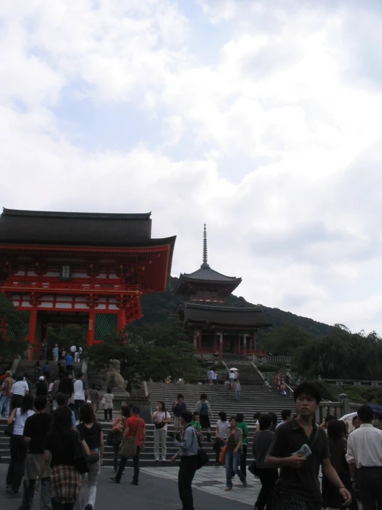 a group of people standing around in front of a pagoda