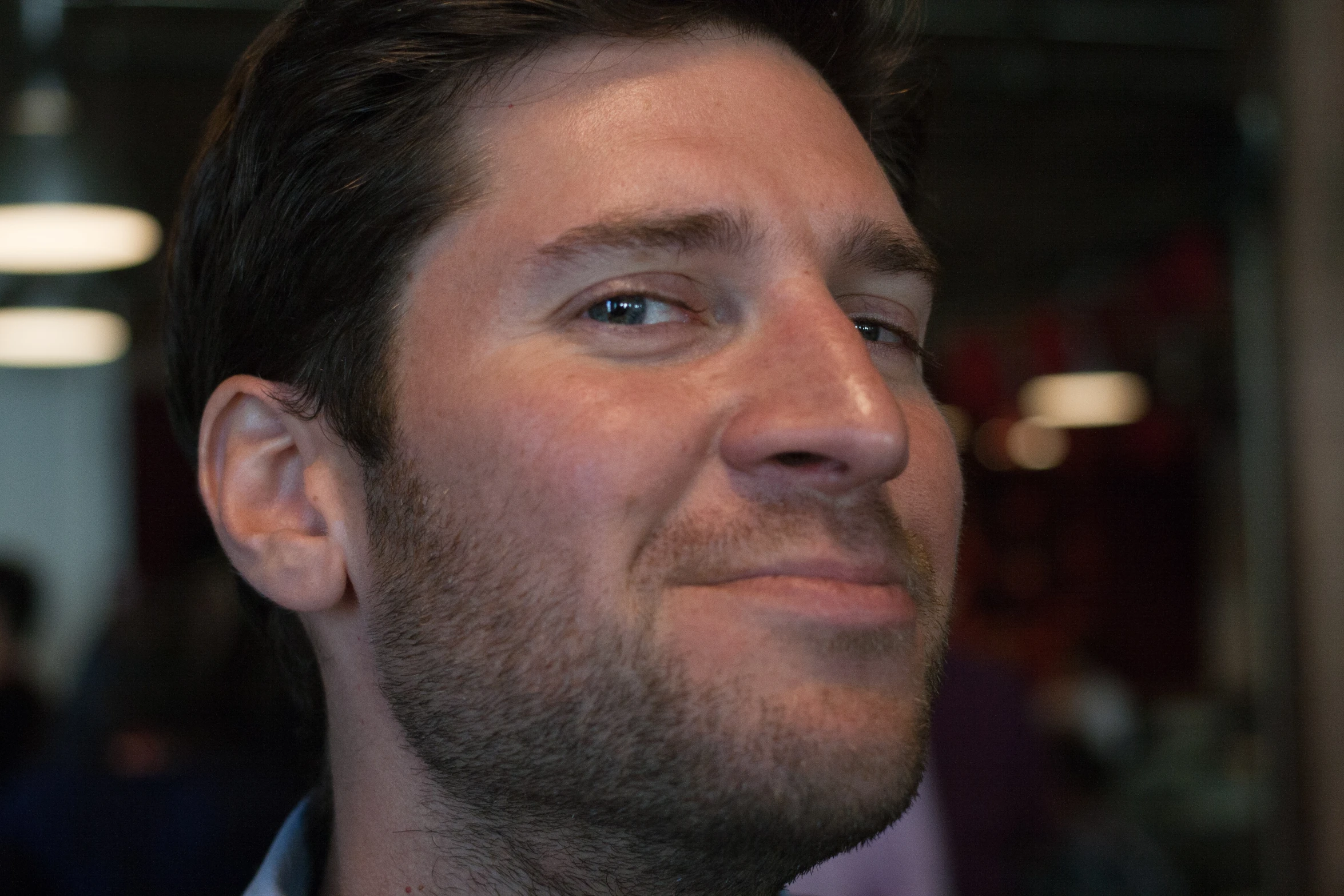 a man in a purple shirt and tie looking away from the camera