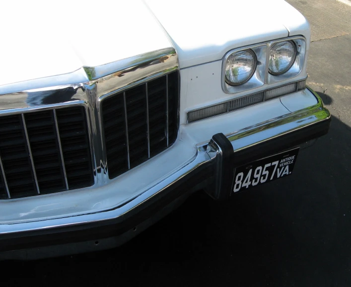 the front bumper of a classic car in the parking lot