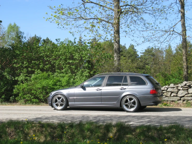 a silver car parked along a tree lined street