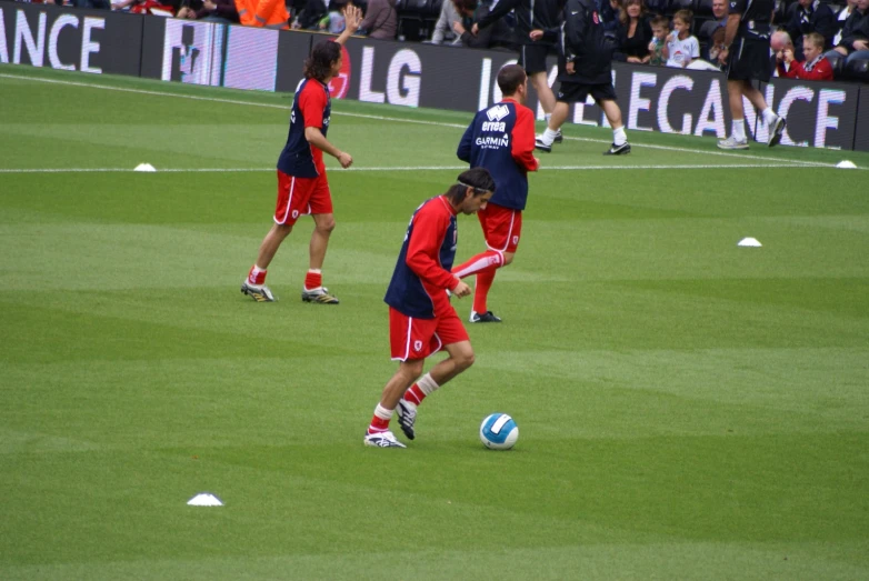 soccer players with red and blue uniforms playing on the field