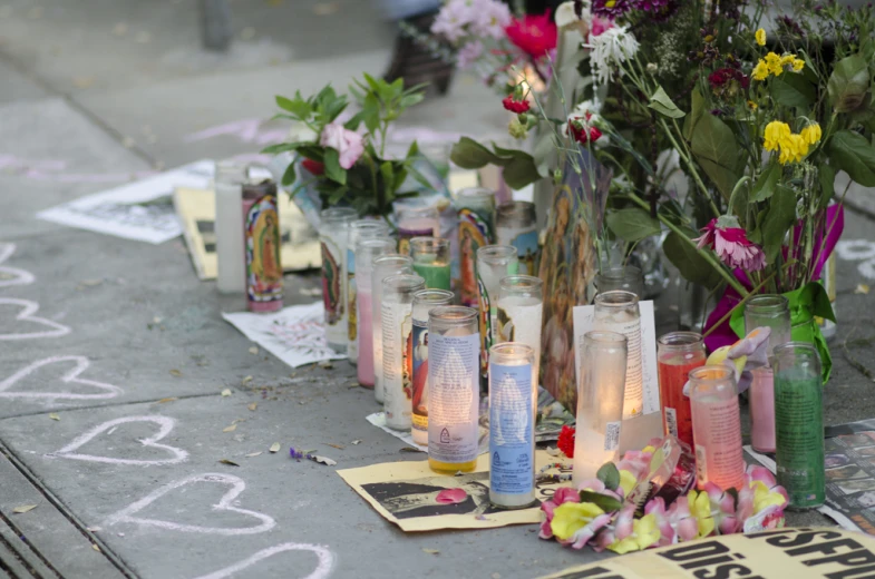 several candles are placed next to flowers and a book