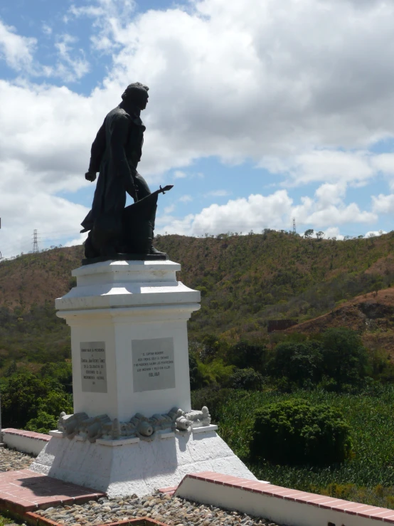 a statue is shown near a hill on a clear day