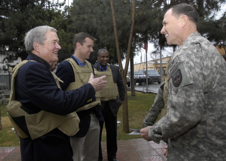 the men are in uniform and talk while the other one is wearing his army fatigues