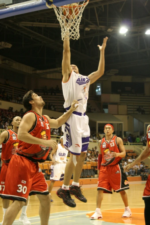 men in white and red uniforms playing basketball