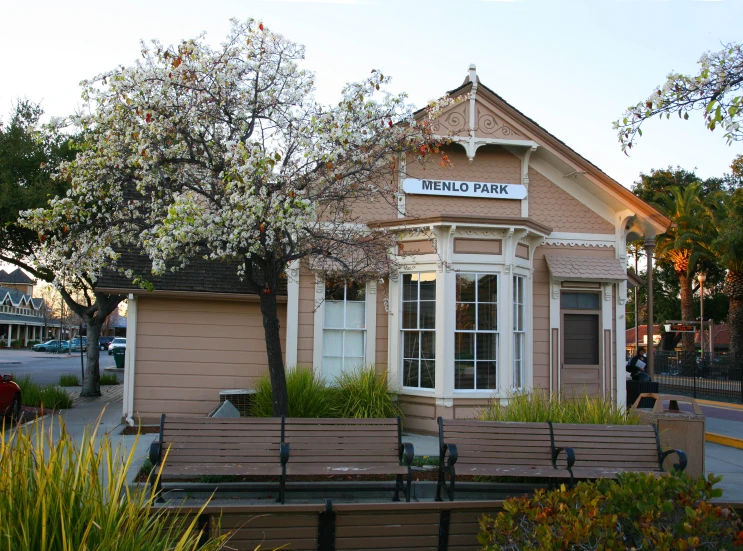 the small store has wooden benches outside of it