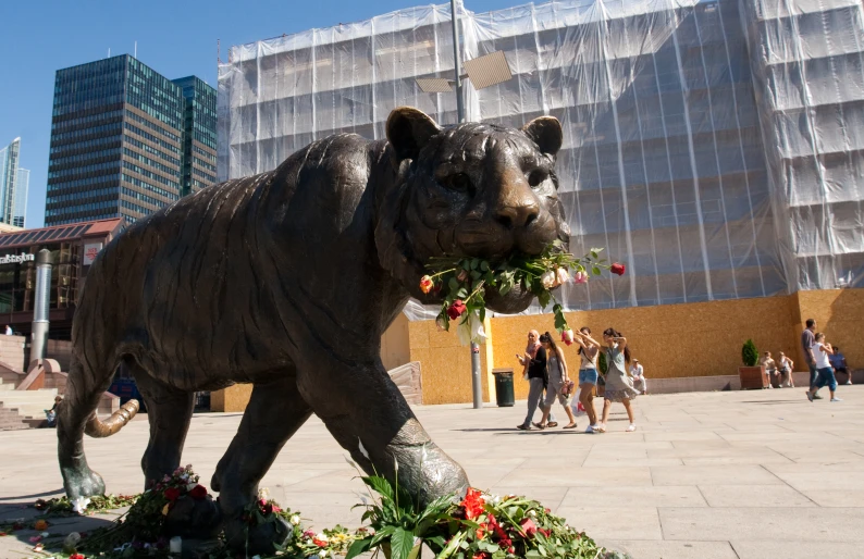 a bronze statue of an elephant carrying flowers