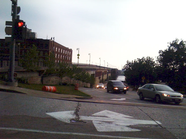 two cars are driving on an intersection with a green traffic light and building