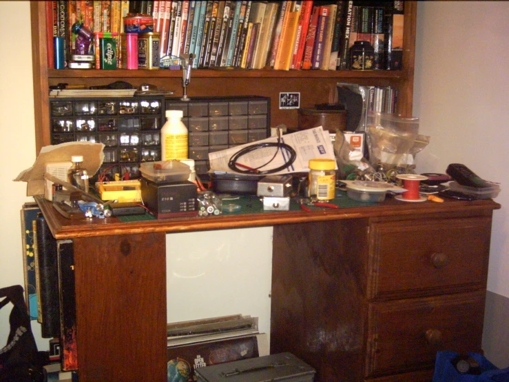 a cluttered home computer desk with many items