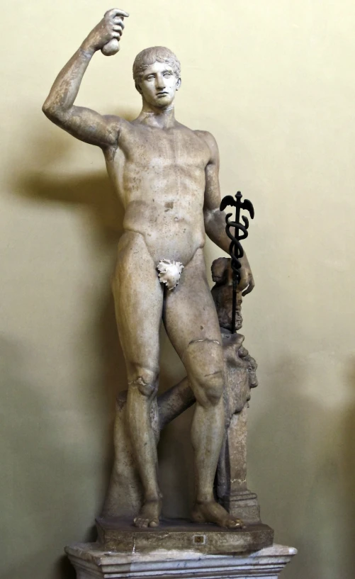 a stone statue holding a litter standing next to a key