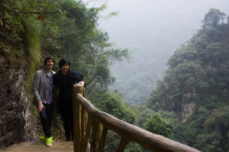 two young men are on a stairway overlooking a canyon