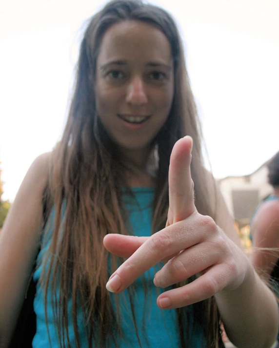 woman with her fingers pointed up to show a peace sign