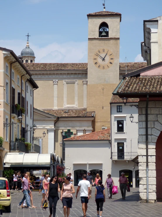 many people are walking around the town square