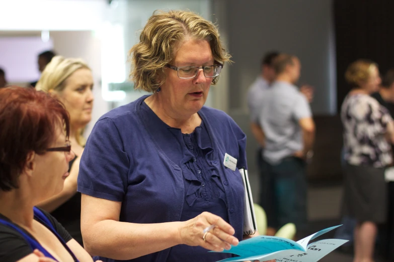 a woman wearing glasses looking at papers