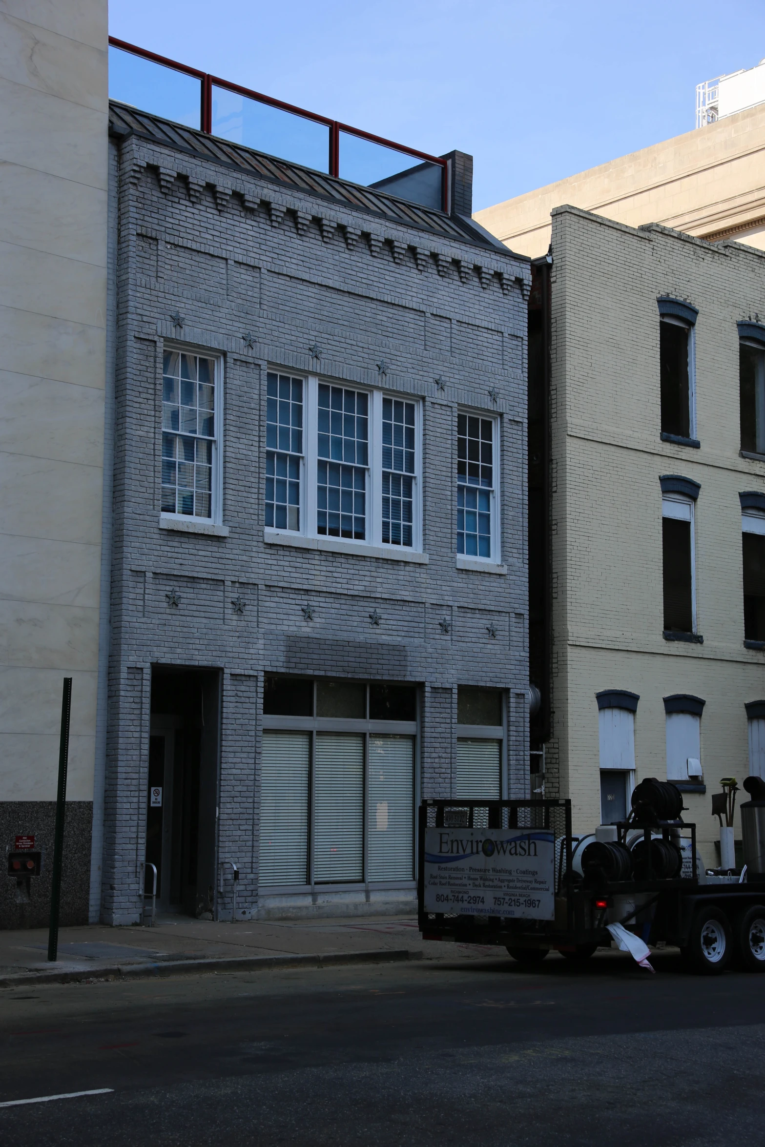 an empty truck is parked in front of two buildings