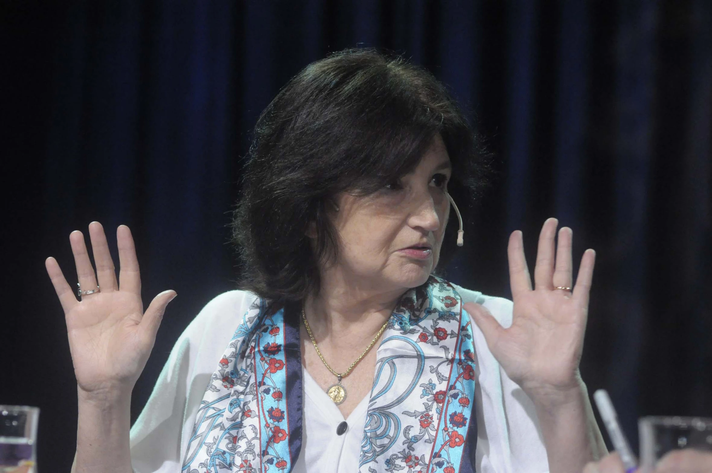 woman with hand outstretched at a table during a conference