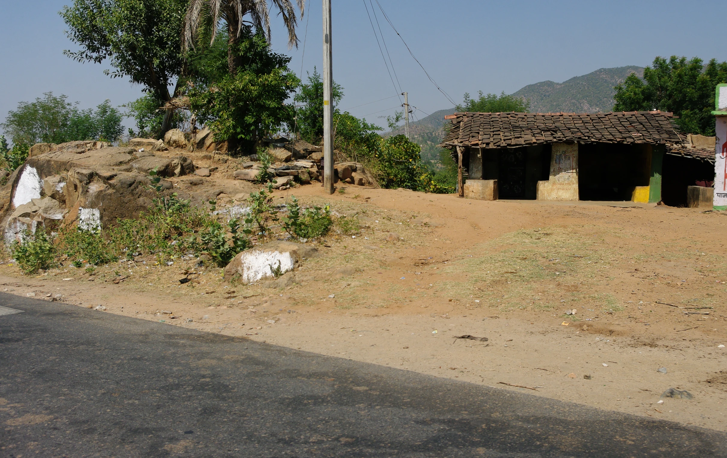 an area with grass, dirt and rocks on the side of it