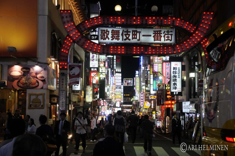 an asian city street with signs and people walking down the street