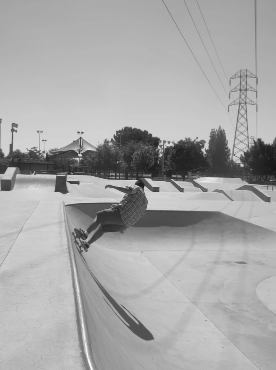 black and white pograph of person on skate board at the edge of ramp