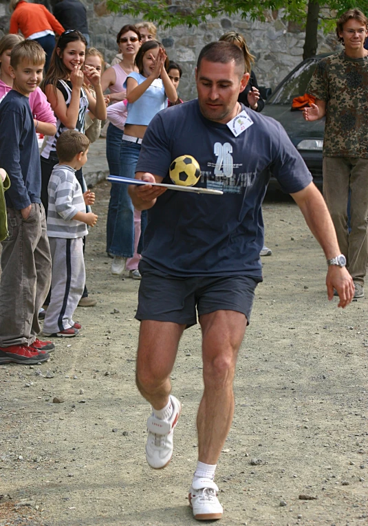 a man in blue is holding a yellow ball