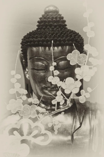 a buddha head covered with flowers and a large piece of paper