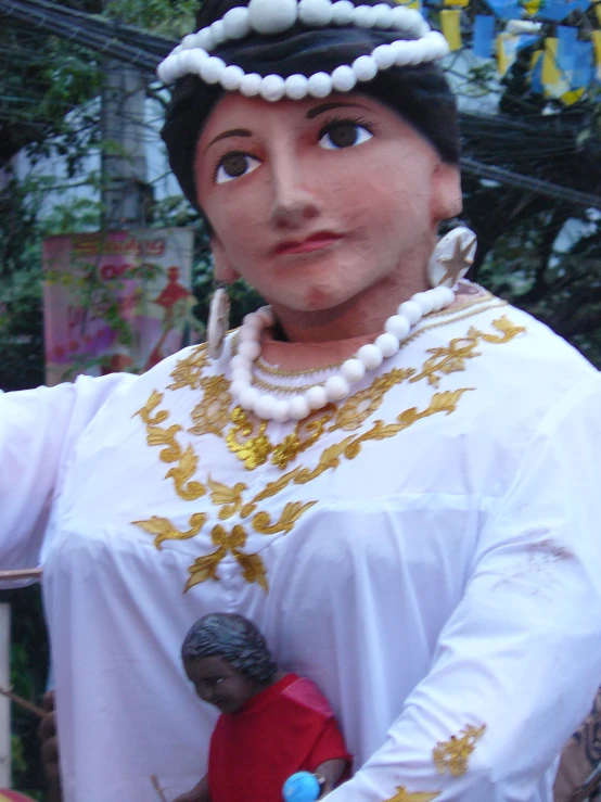 a large statue holding a baby doll next to a park