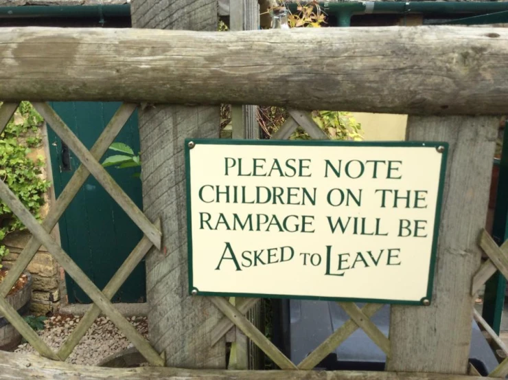 a sign posted on a fence warning of children on the damage
