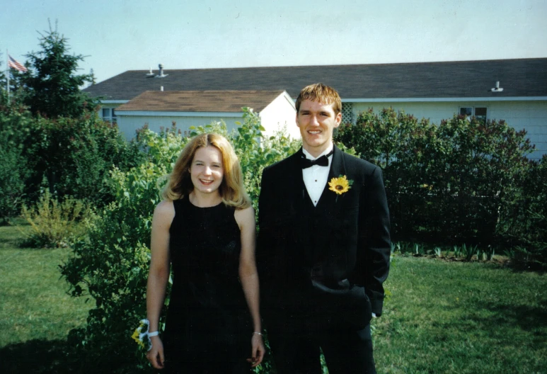 a man and woman in formal wear pose for a picture