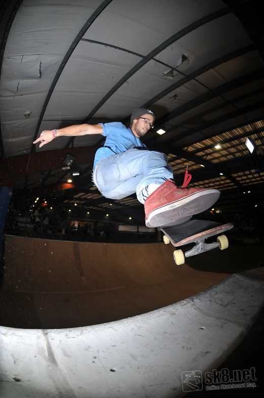 a man skateboarding on the rim of a bowl in a sports facility