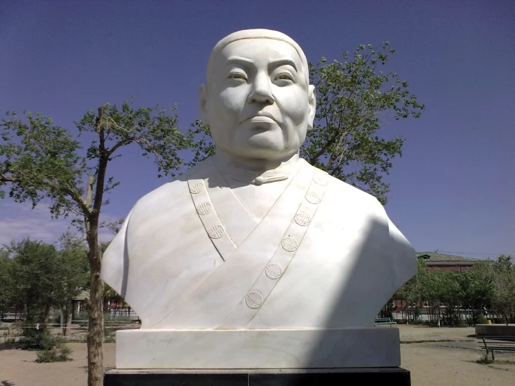 a large statue of a man in an uniform with trees around him