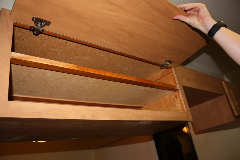 a person places a knife on a wooden shelf