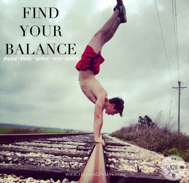 a man doing a handstand on railroad tracks