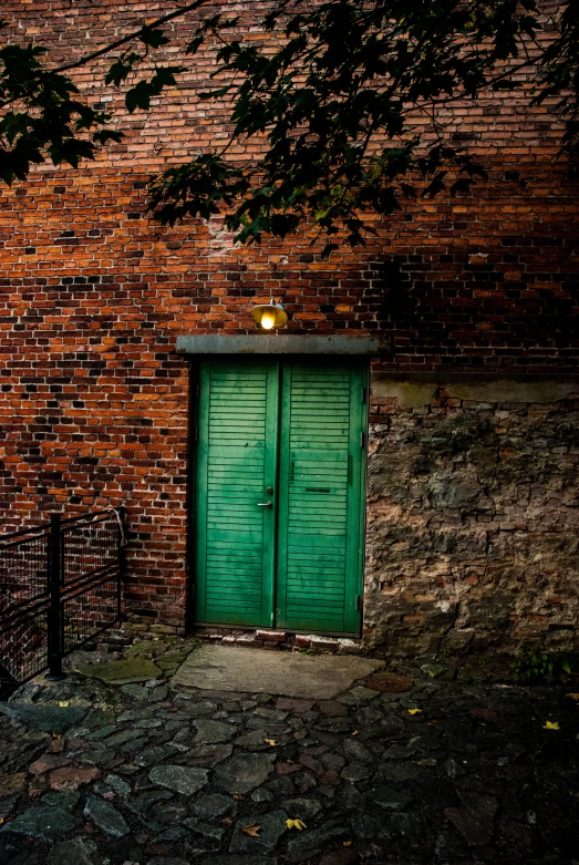 a green door in front of a brick wall