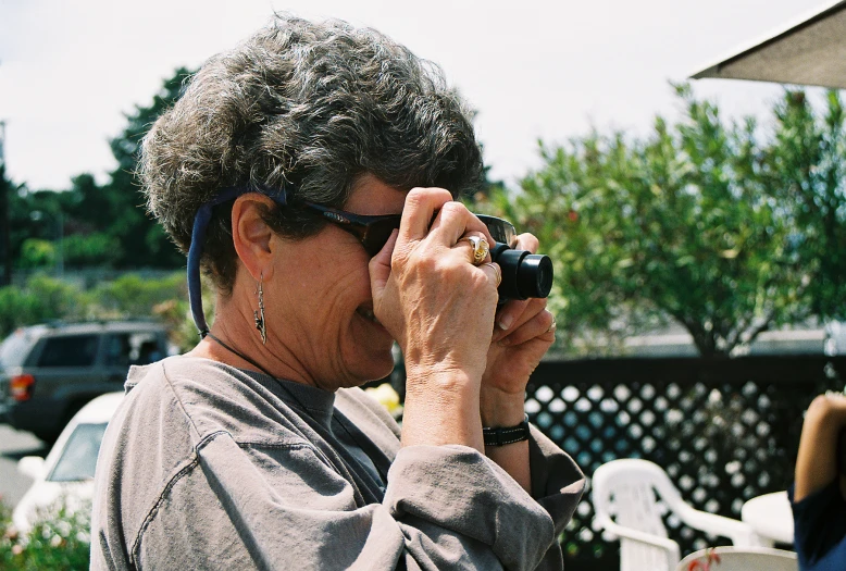 a woman is taking pictures with her camera outside