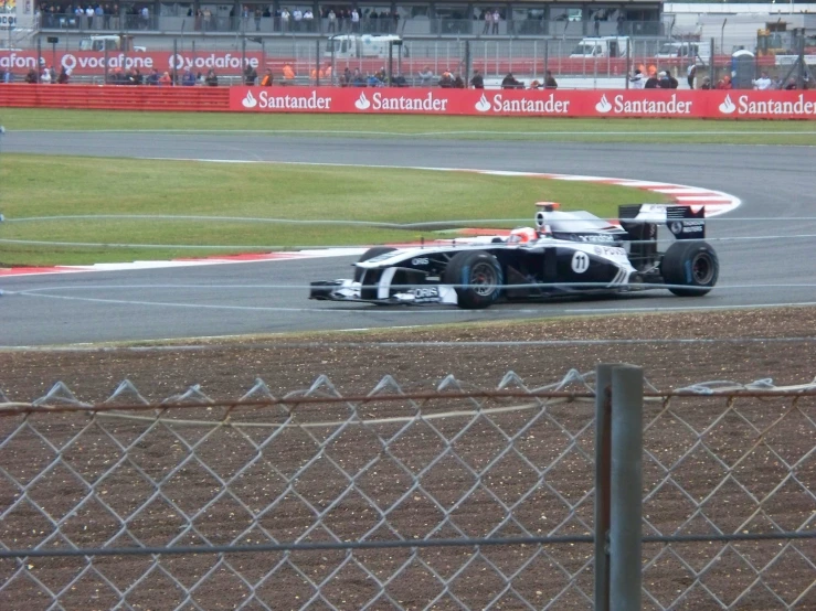 a black and white racing car drives down a track